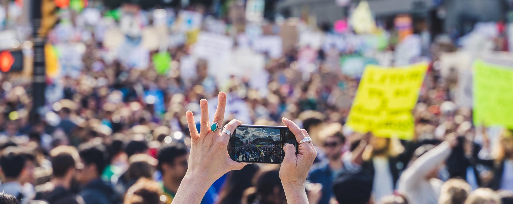 Protester takes a photo of the assembled crowd