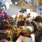 Assembled crowd of protesters holding up banners